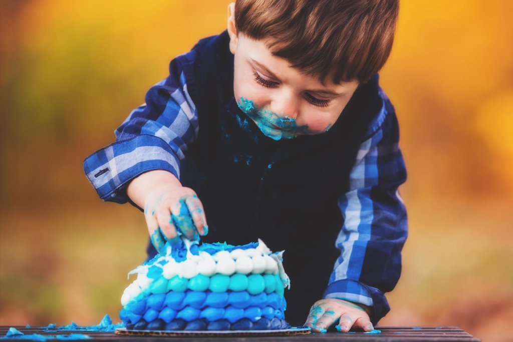 a young boy blowing out the candles on a cake