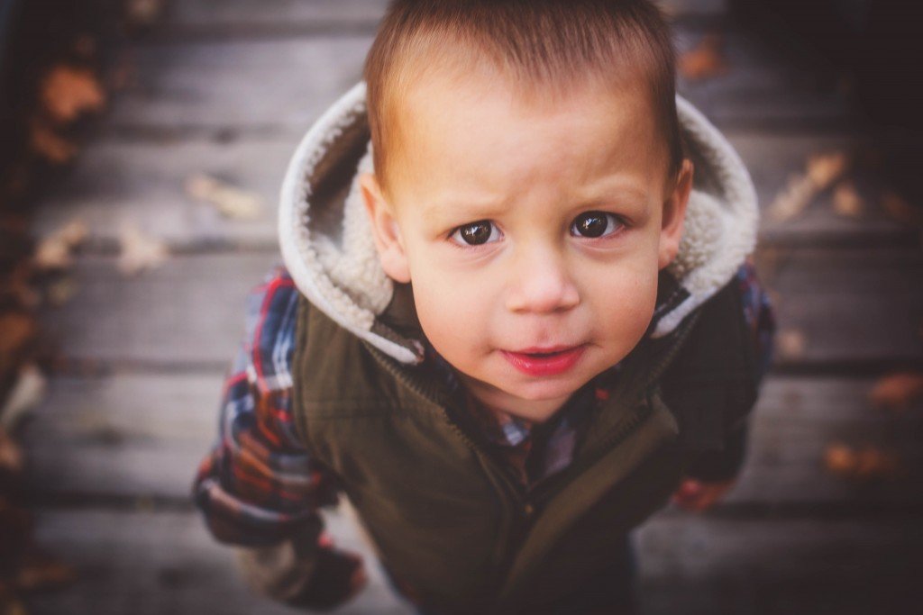 a little boy with a hoodie on looking at the camera