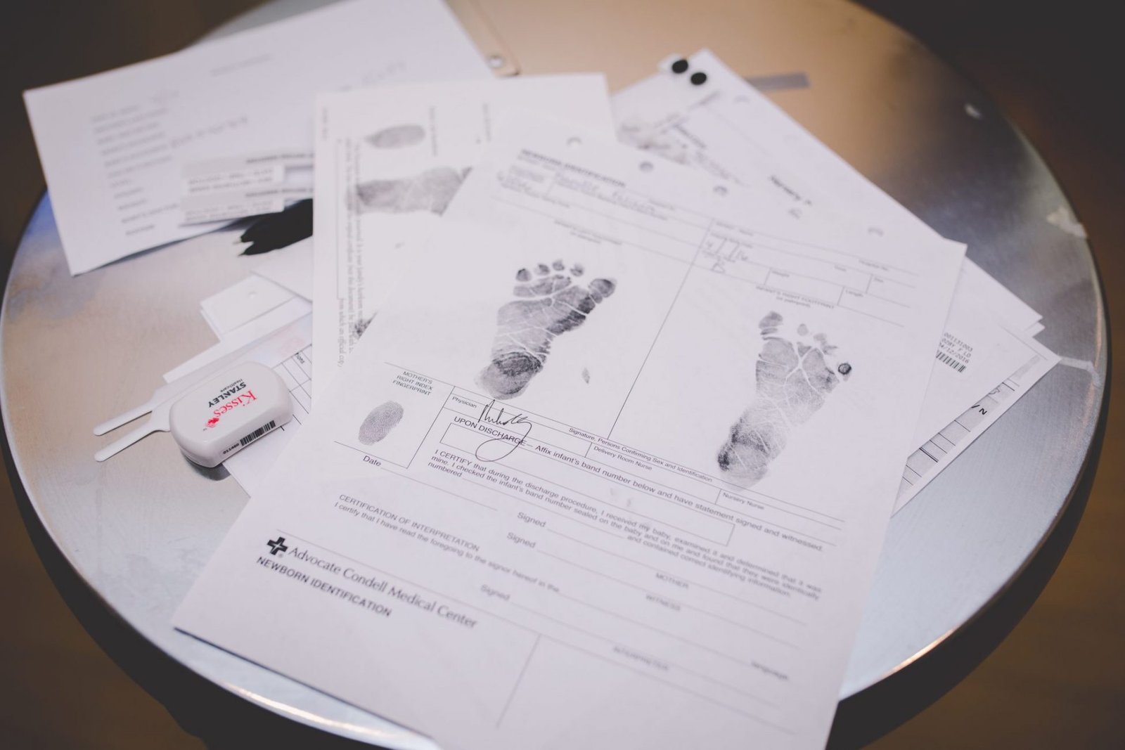 a table topped with lots of papers and baby footprints
