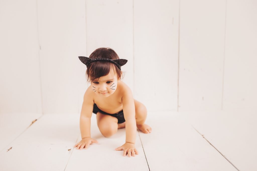 a baby girl wearing a black cat costume