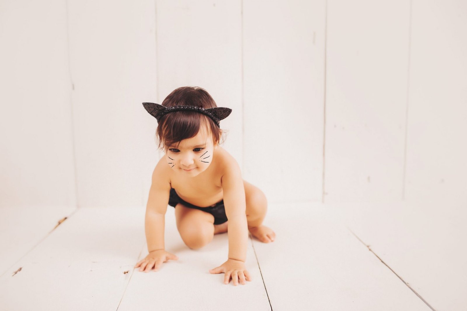 a baby girl wearing a black cat costume