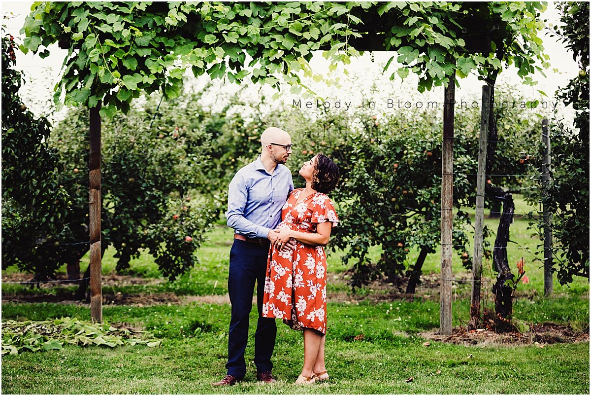 a man and woman standing in front of some trees
