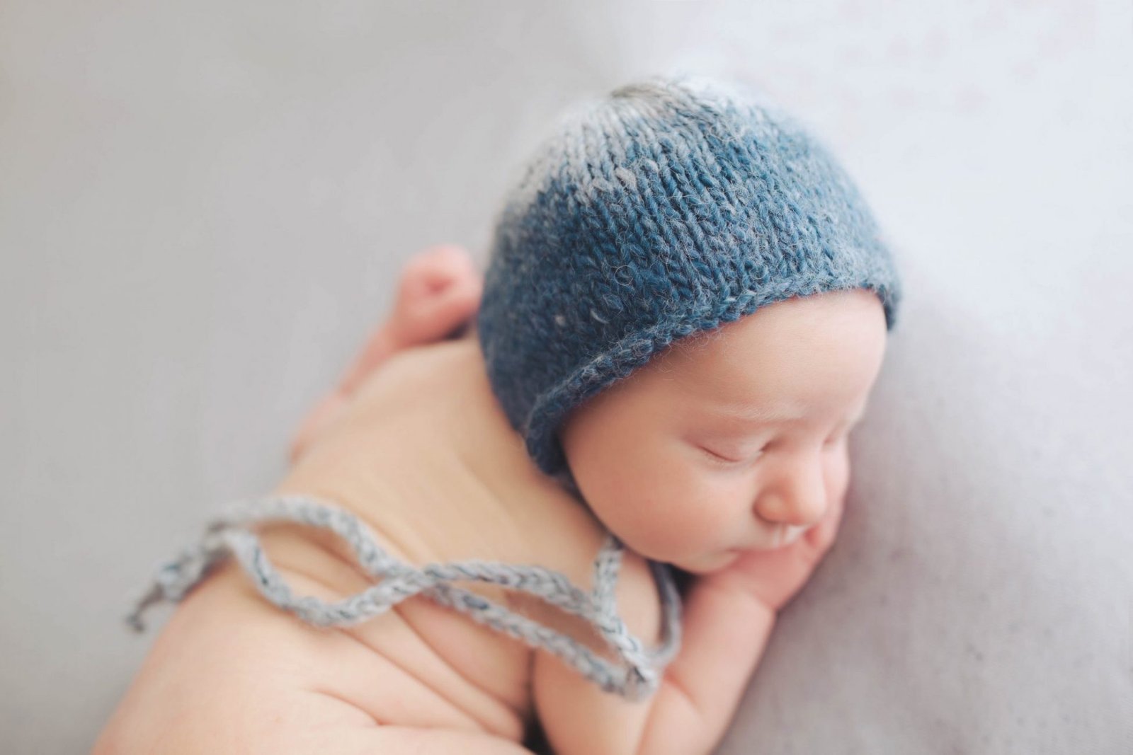 a newborn baby wearing a blue knitted hat
