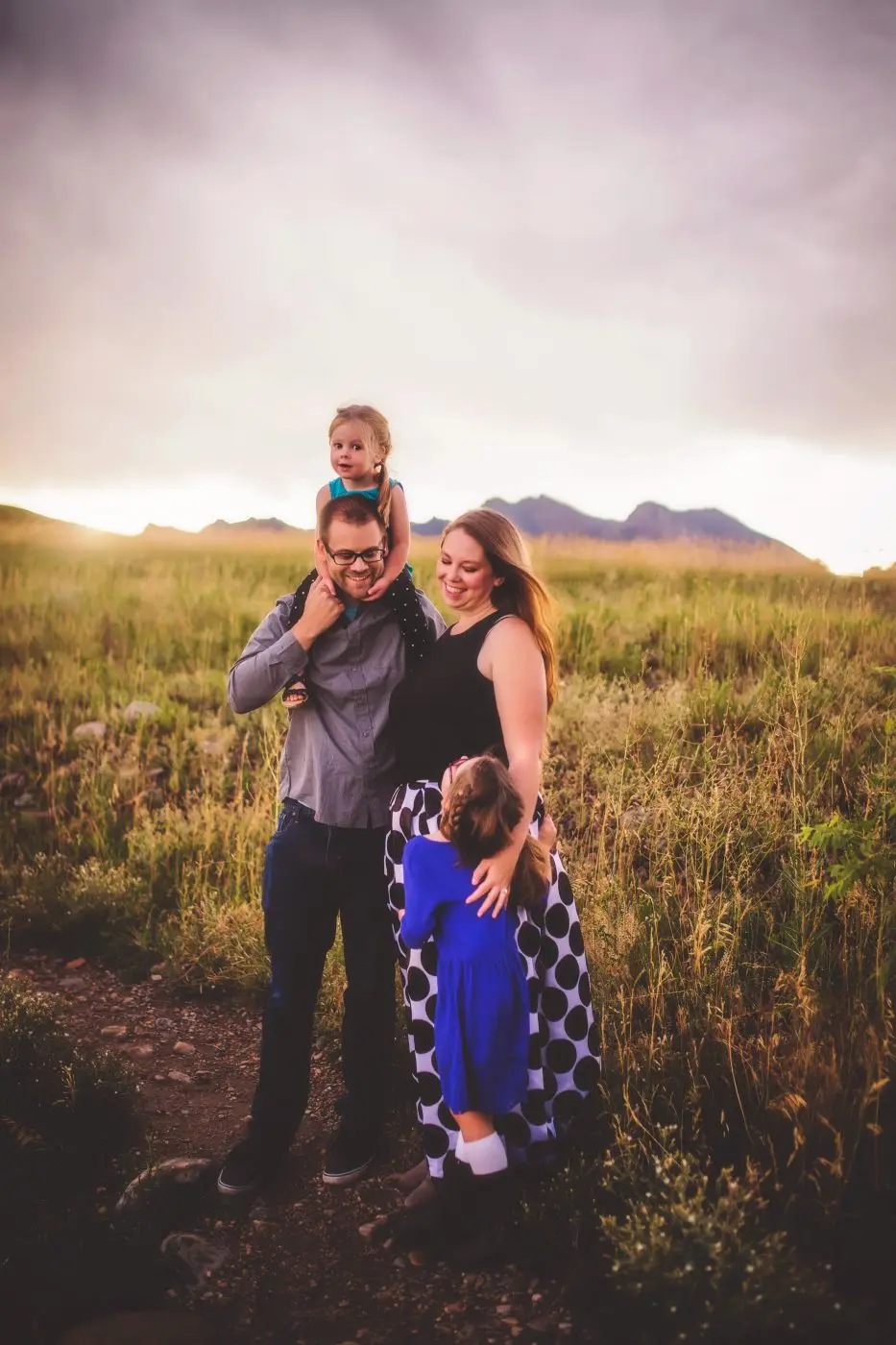 a man, woman and child standing in a field