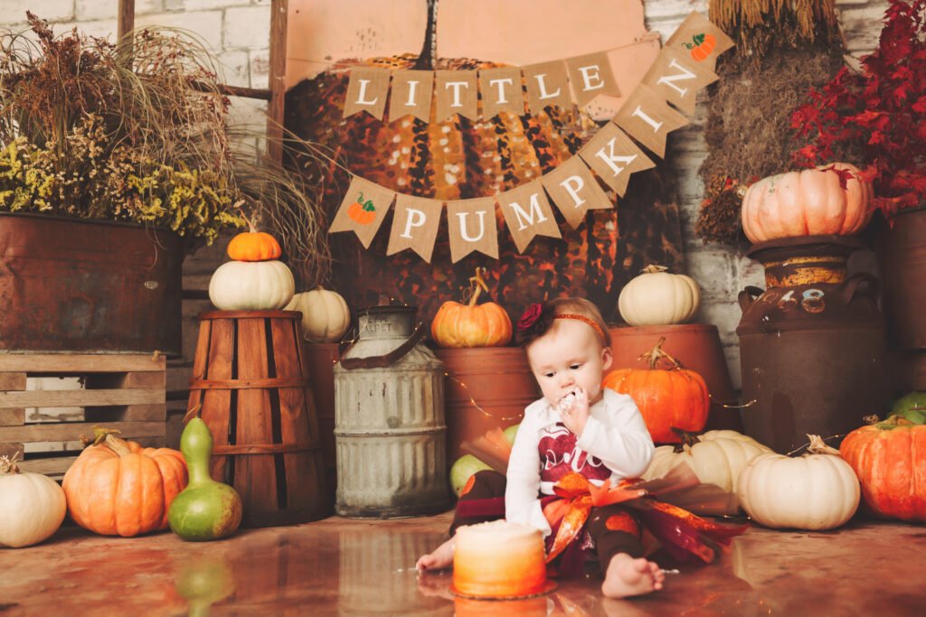 a baby sitting on the floor surrounded by pumpkins
