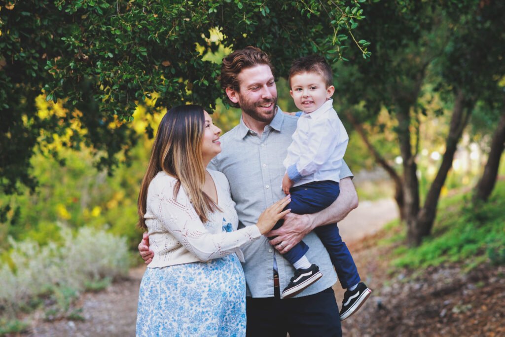 a man and woman holding a small boy in their arms